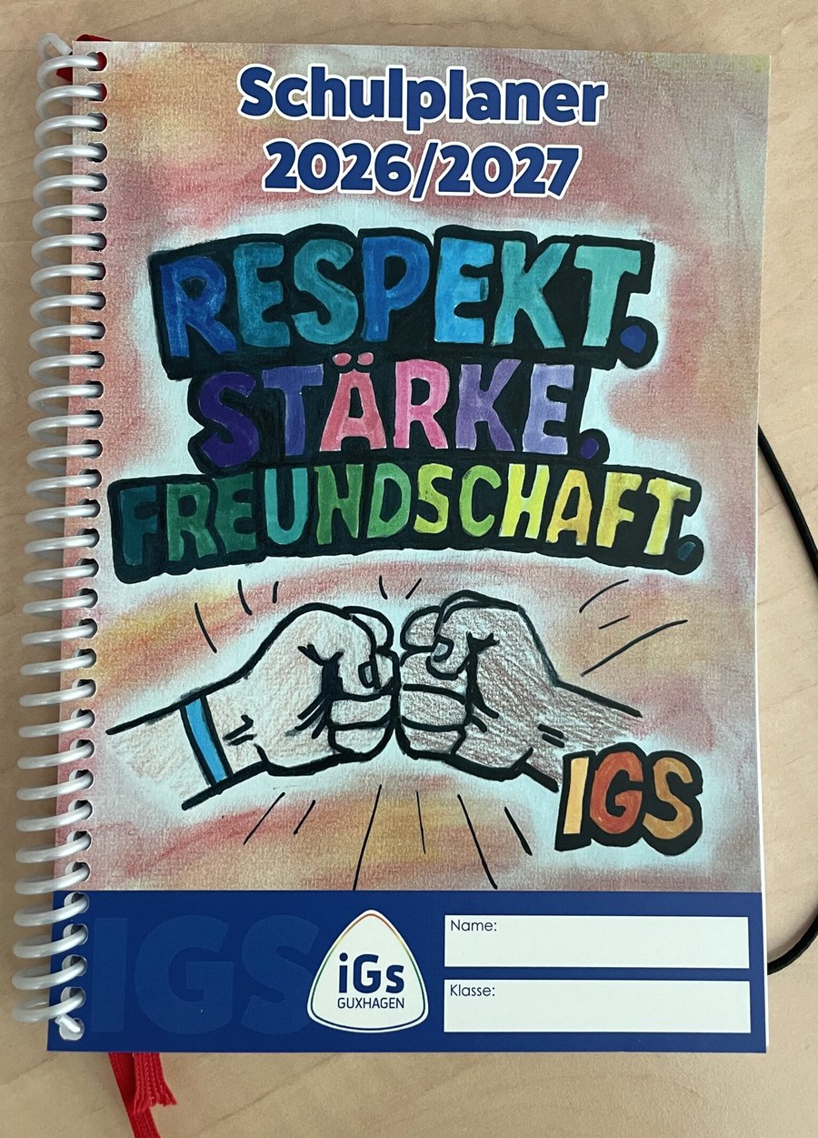 Schulplaner 2026/2027 der IGS Guxhagen. Auf dem Cover die Siegerzeichnung zum Thema Freundschaft: zwei Fäuste stoßen aneinander, darüber steht in bunten Buchstaben „Respekt. Stärke. Freundschaft.“