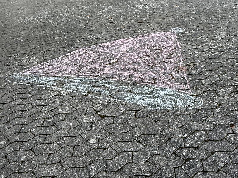 Kreidebild auf dem Schulhof: eine große rosa Weihnachtsmütze