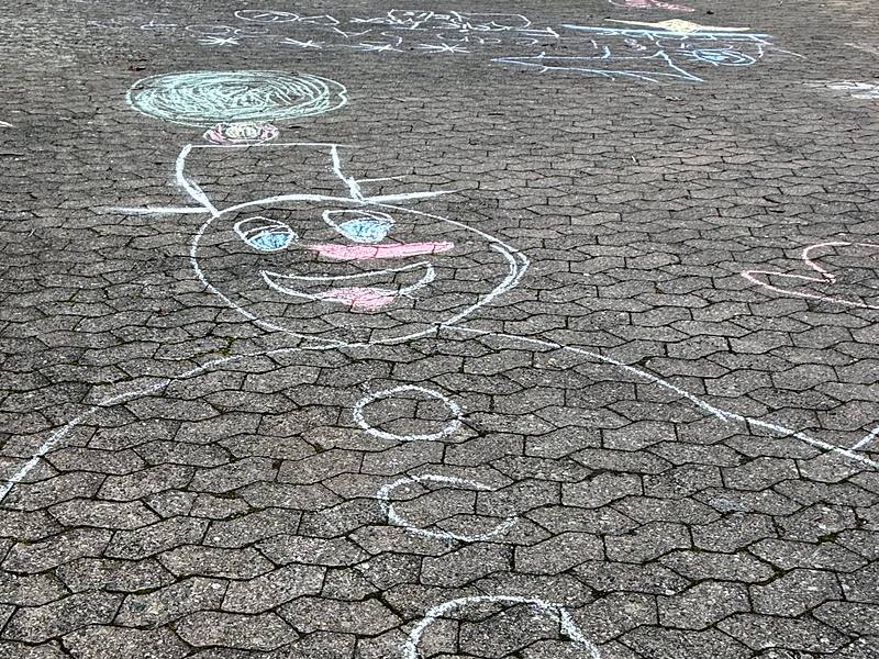 Kreidebild auf dem Schulhof: ein großer Schneemann mit Mütze
